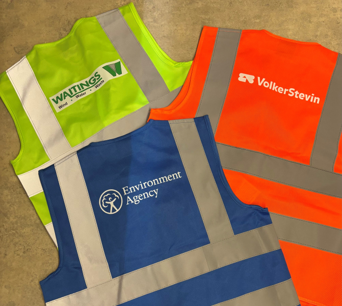 Three mini hi-vis vests, one in yellow, one in orange and one in blue