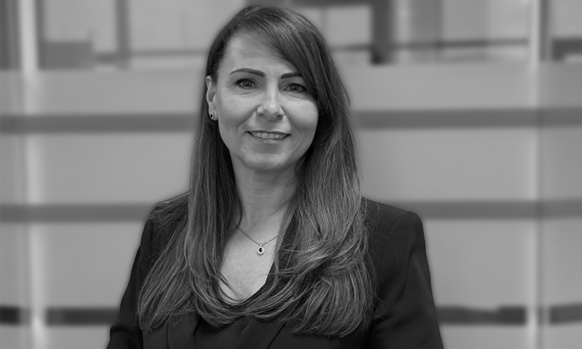 Picture of a woman smiling at the camera in black and white.